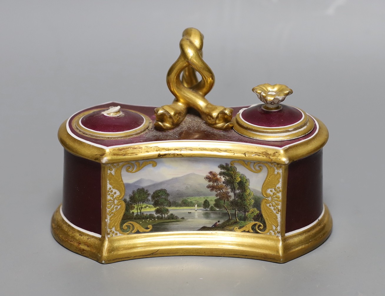 A Flight Barr and Barr ink stand painted with ‘Scene on the banks of Keswick Lake, the handle with serpent heads, printed mark in red, 16 cms wide